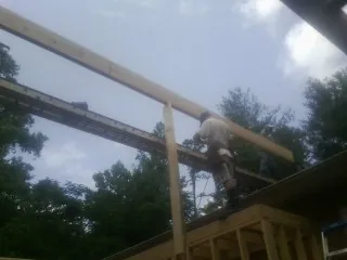 Carpenter setting a ridge beam over a new addition frame — Ice Dam Removal by Roofing Brothers in Clementon