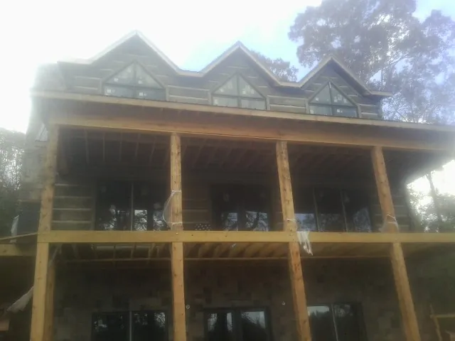 Dormers and porch framing on a large log home under construction — Roof Coating work by our crew in Clementon
