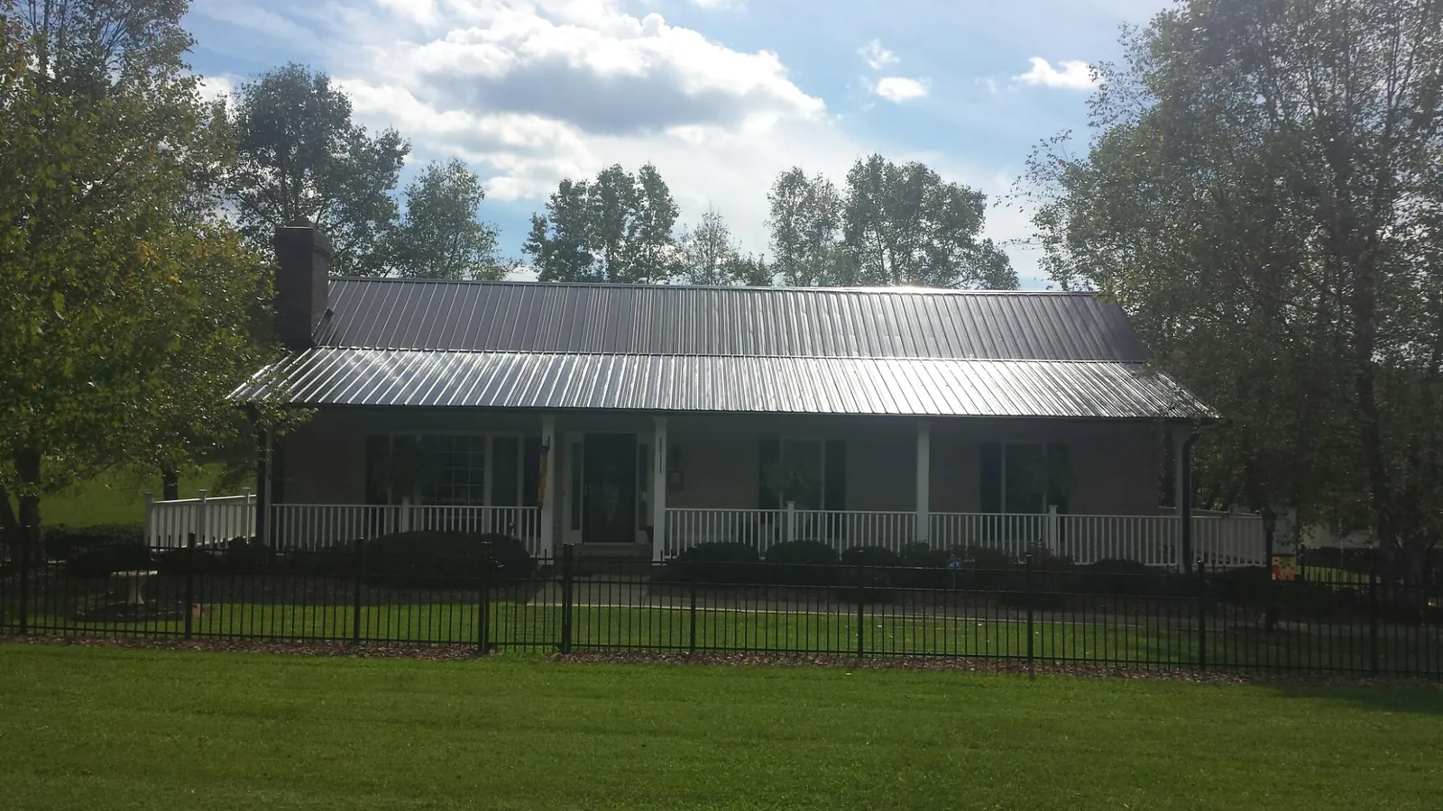 Gray metal roof on a brick ranch with a full width front porch — Gutter Guard Installation work by our crew in Clementon