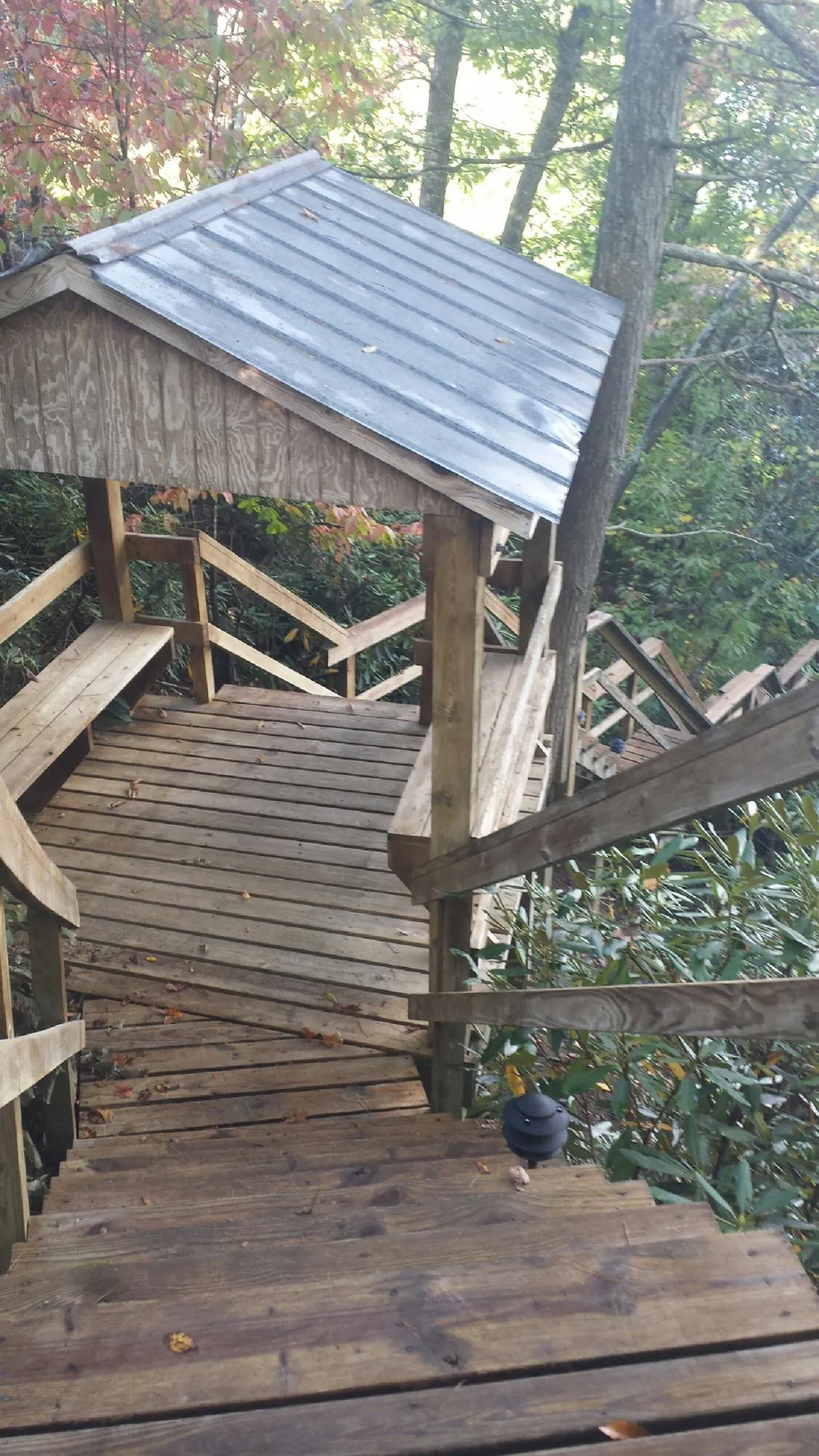 Metal roofed shelter over wooden steps on a wooded walkway — Skylight Repair & Installation work by our crew in Clementon